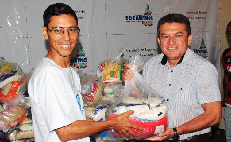 Representante da Sociedade São Vicente de Paula - Creche Monte do Carmo em Taquari - recebe cesta das mãos do Secretário de Esporte Salim Milhomem